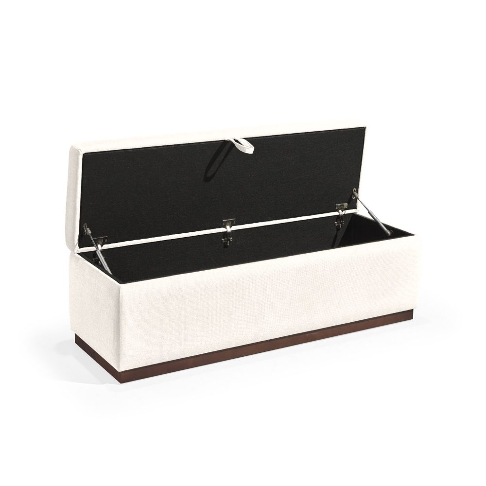 Banqueta retangular com topo almofadado, revestido em tecido branco, com uma base de madeira. Inclui um puxador em tecido na parte frontal para abrir o compartimento interno de arrumação, combinando funcionalidade e estilo.