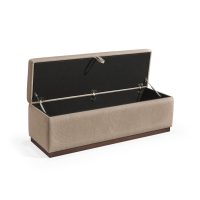 Banqueta retangular com topo almofadado, revestido em tecido castanho, com uma base de madeira. Inclui um puxador em tecido na parte frontal para abrir o compartimento interno de arrumação, combinando funcionalidade e estilo.