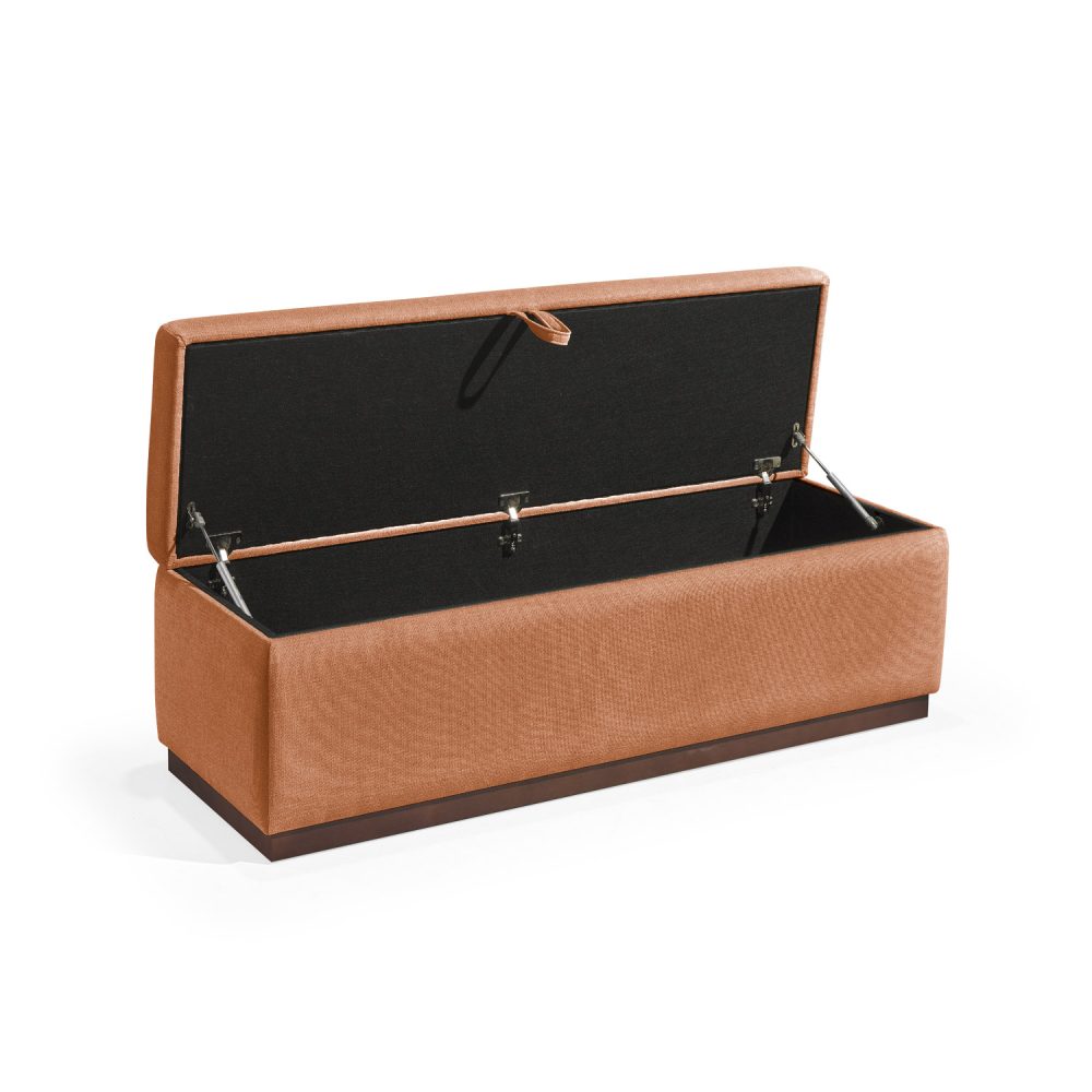 Banqueta retangular com topo almofadado, revestido em tecido laranja, com uma base de madeira. Inclui um puxador em tecido na parte frontal para abrir o compartimento interno de arrumação, combinando funcionalidade e estilo.