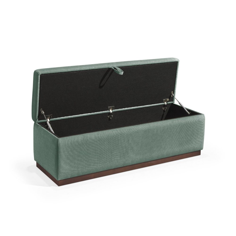 Banqueta retangular com topo almofadado, revestido em tecido verde, com uma base de madeira. Inclui um puxador em tecido na parte frontal para abrir o compartimento interno de arrumação, combinando funcionalidade e estilo.