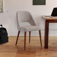 Cadeira Estofada em Bege com Pés em Nogueira junto a secretária e mochila