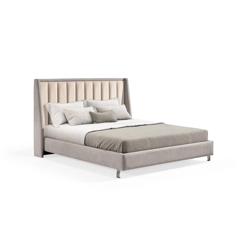 Cama de casal estofada em tecido cinza claro, com cabeceira alta e painéis verticais estofados em tom bege.
