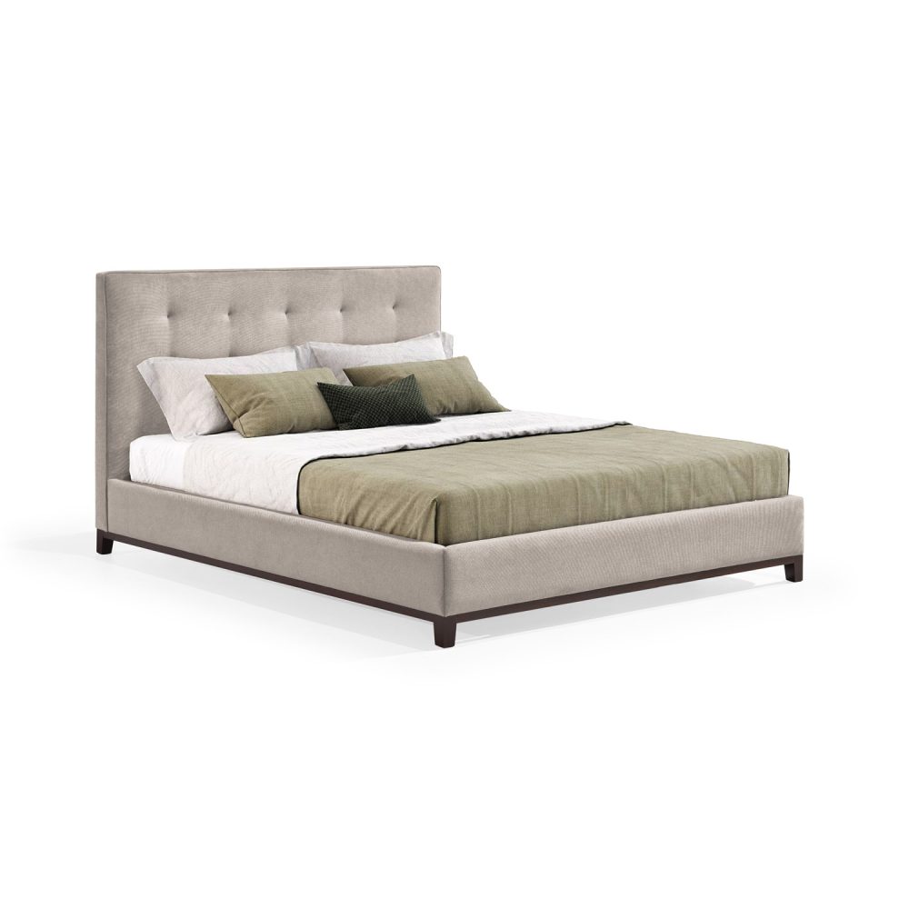 Cama moderna com cabeceira acolchoada e estofada em tecido bege, com lençóis brancos, uma manta verde e várias almofadas em tons de verde e branco. A estrutura da cama é revestida com tecido bege e possui pés de madeira escura.