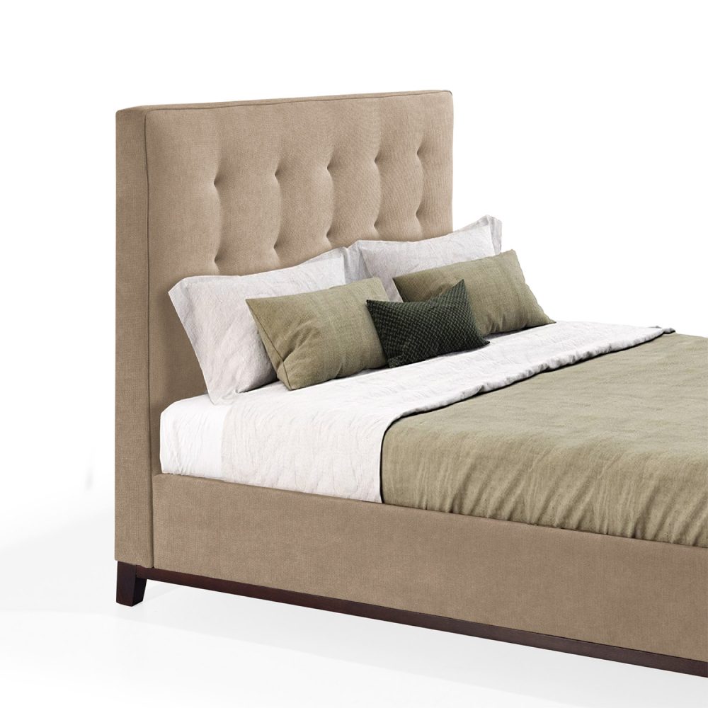 Cama moderna com cabeceira acolchoada e estofada em tecido amarelo, com lençóis brancos, uma manta verde e várias almofadas em tons de verde e branco. A estrutura da cama é revestida com tecido amarelo e possui pés de madeira escura.