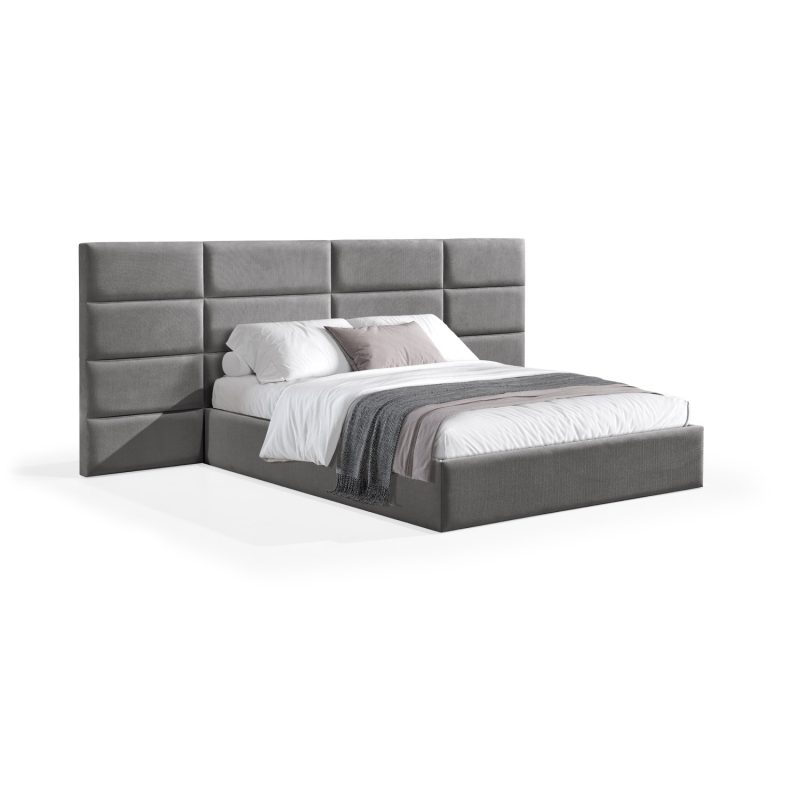 Cama moderna com cabeceira acolchoada cinzenta, lençóis brancos, cobertor cinzento e várias almofadas em tons de cinza e branco, com estrutura estofada no mesmo tecido cinzento.